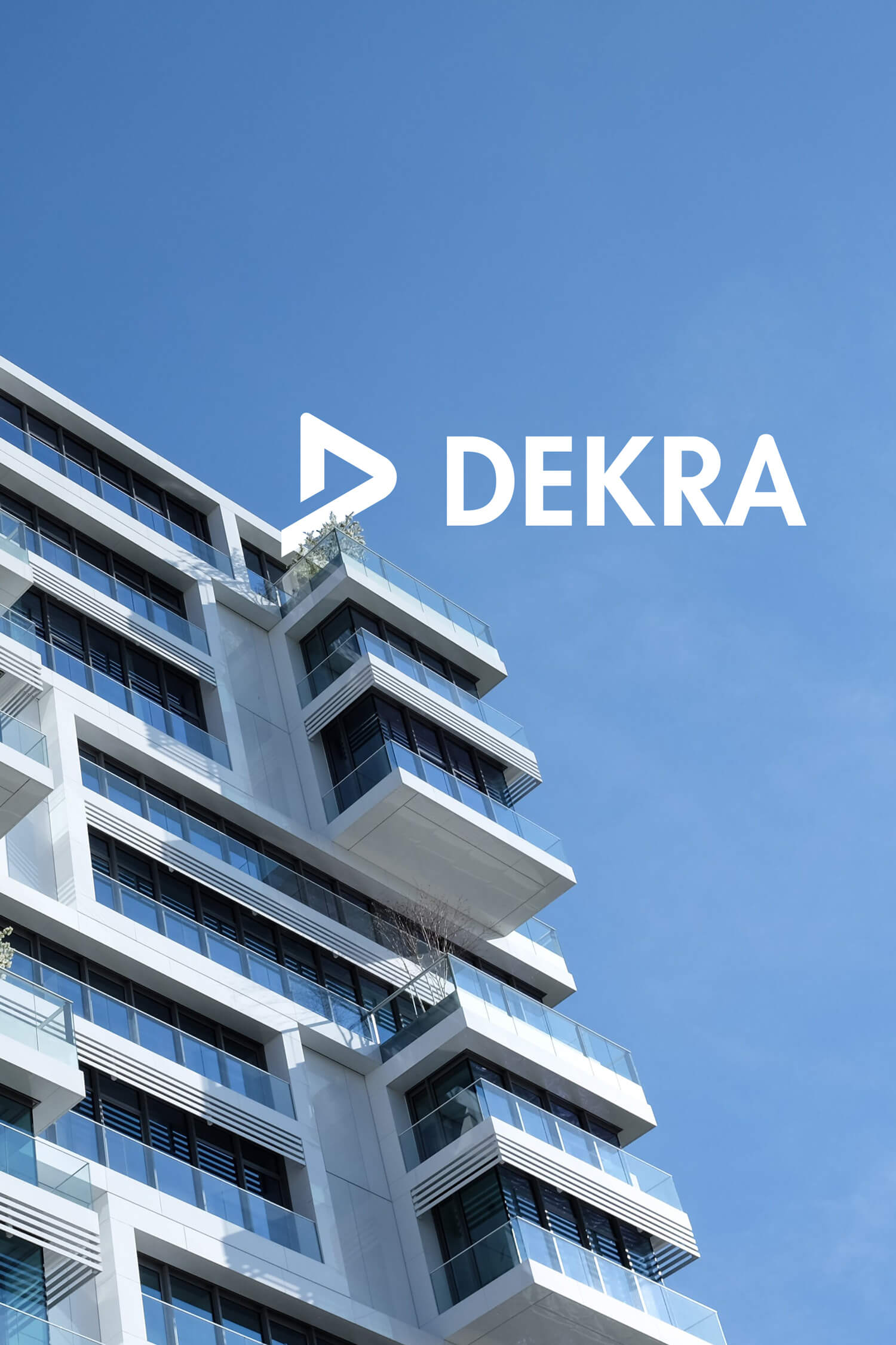 Ein Hochhaus mit blauem Himmel, Logo der Dekra