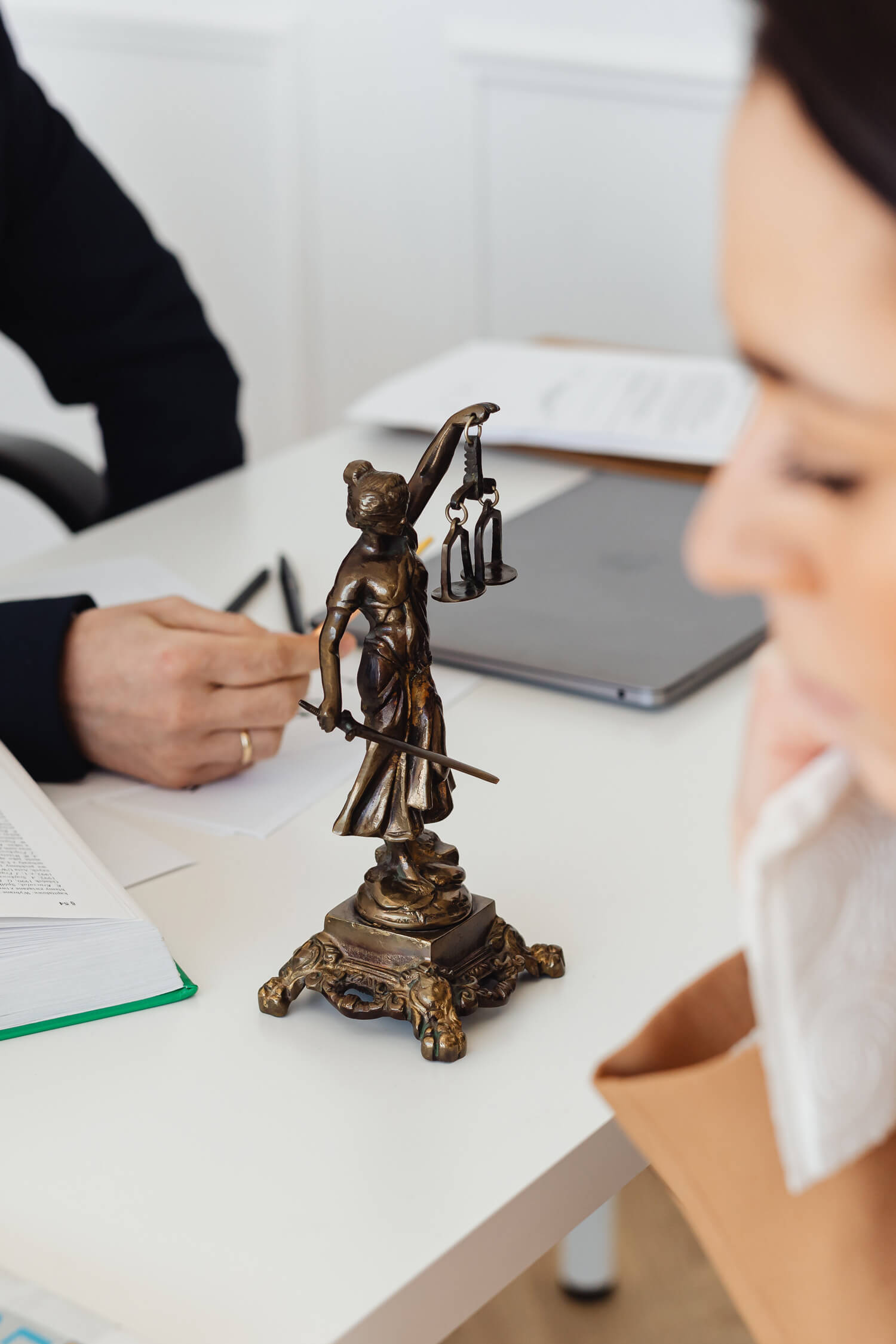 Justizia als Bronzefigur auf einem Schreibtisch